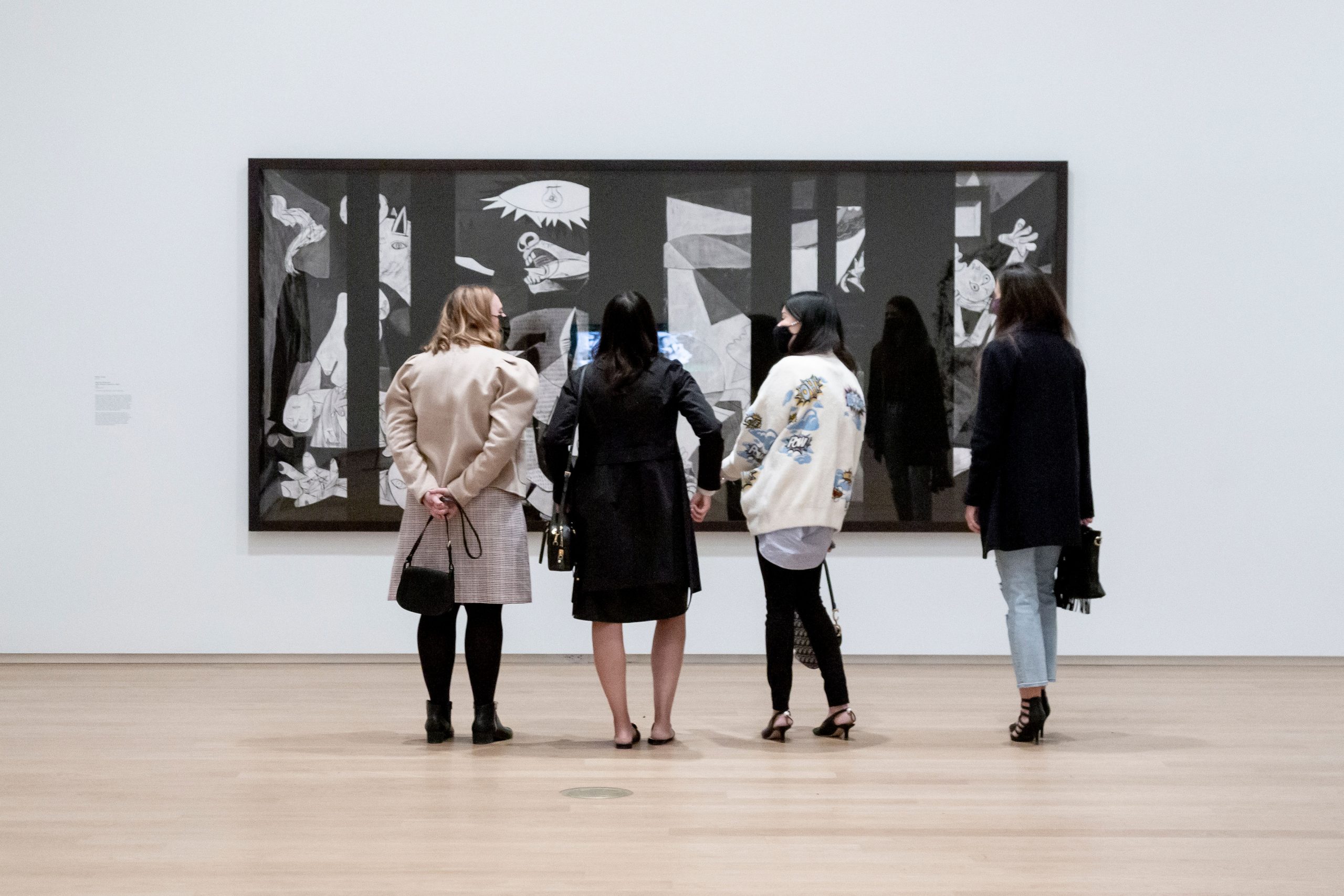 4 people standing in front of an artwork